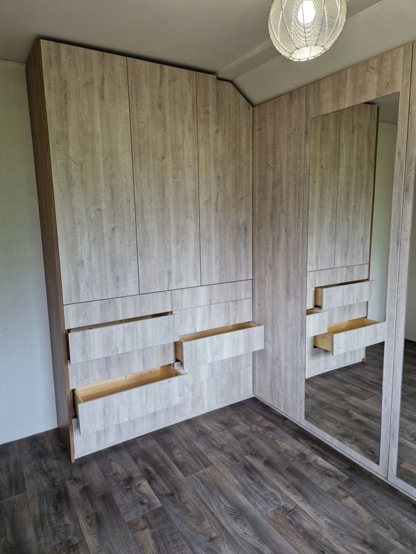 Dressing sur mesure en angle sous la pente du plafond, tiroirs ouverts