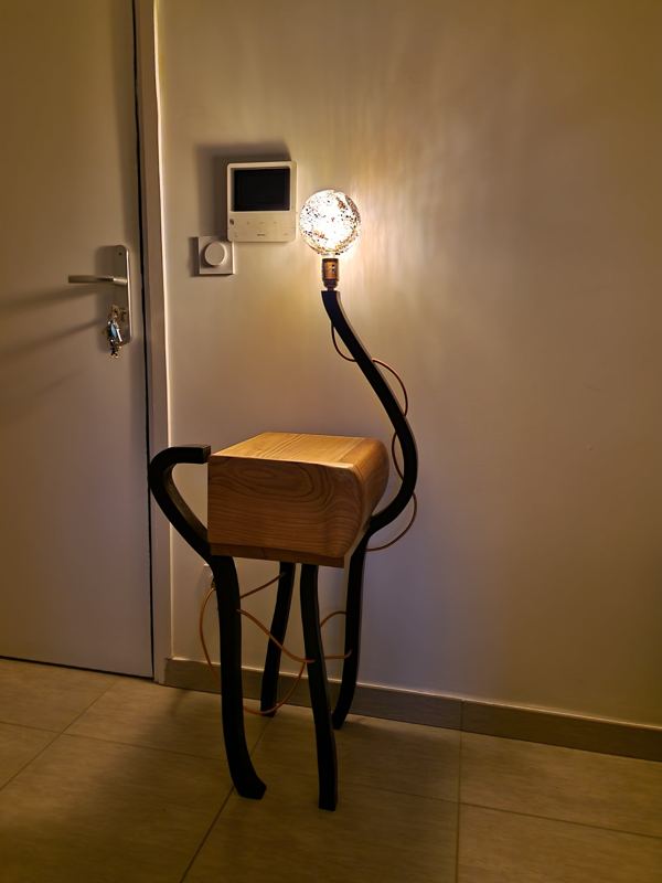 Lampadaire allumé, pieds courbes en frêne laqué noir et caisson vide-poche en noyer